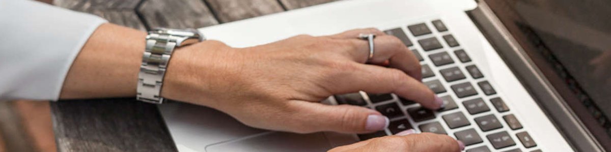 Person creating document on laptop